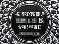 「祝 事務所開き、贈り先の会社名、開設日の日付、贈り主の会社名」を底面に彫刻した、事務所開設祝い用のガラス製灰皿