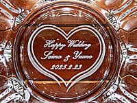 「Happy wedding、新郎と新婦の名前、結婚式の日付」を底面に彫刻した、結婚祝い用のガラス製灰皿