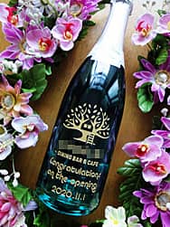 開店祝い用のシャンパン(お店のロゴマークと、Congratulations on the opening、日付をボトル側面に彫刻)