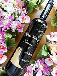 「新郎と新婦が並んだシルエットのイラスト」と「Happy Wedding、新郎と新婦の名前、結婚式の日付」をボトル側面に彫刻した、結婚祝い用のワイン