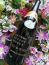 「今まで大切に育ててくれてありがとう」を瓶の側面に彫刻した、新郎新婦から両親へ贈る焼酎