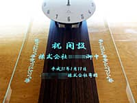 「祝開設 株式会社○○御中」を前面ガラスに彫刻した、事業所の開設祝い用の掛け時計