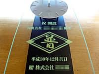 「会社のマーク」と「祝 開設、有限会社○○御中」を彫刻した、営業所の開設祝い用の掛け時計
