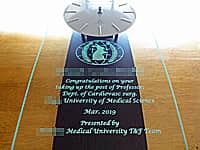 「大学のマーク」と「お祝いメッセージ、先生の名前」を彫刻した、教授就任祝い用の掛け時計