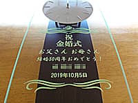 「祝 金婚式、お父さん お母さん 結婚50周年おめでとう、日付」を前面ガラスに彫刻した、両親の金婚式祝い用の掛け時計