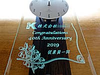 ��Ђ̎��N�j���p�̊|�����v�i��Ђ̃��S�}�[�N�ƁACongratulations 40th anniversary 2019 �]�ƈ��ꓯ��O�ʃK���X�ɒ����j