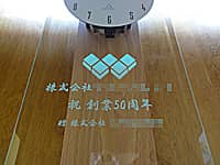 �n��50���N�j���p�̊|�����v�i���鑊���̃��S�}�[�N�ƁA�j�n��50���N ��������Ё�����O�ʃK���X�ɒ����j