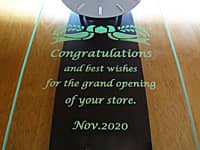 開店祝い用の掛け時計(Congratulations and best wishes for the grand opening of your store. Nov.2020を、掛け時計の前面ガラスに彫刻)