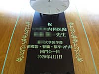 病院の開院祝い用の掛け時計(祝○○内科医院 ○○先生 ○○大学医学部同門会一同を、掛け時計の前面ガラスに彫刻)