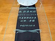 �u�j �В��A�C�A��\������В������l�v��O�ʃK���X�ɒ��������A�������̎В��ւ̏A�C�j���p�̊|�����v