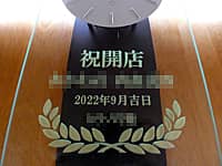 「祝開店、店名、開店日の日付、贈り主の名前」を前面ガラスに彫刻した、飲食店の開店祝い用の振り子時計