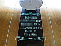 「祝御開業 ○○歯科○○院長 ○○大学病院歯周病科医局員一同」を前面ガラスに彫刻した、歯科医院の開業祝い用の振り子時計