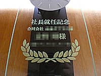 「社長就任記念、合同会社○○、○○様、○○一同」を前面ガラスに彫刻した、社長就任祝い用の振り子時計