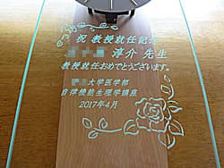 「祝 教授就任記念 ○○先生、大学名、日付」を前面ガラスに彫刻した、教授就任祝い用の掛け時計