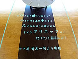 「クリニックの名前、日付、贈り主の名前」を前面ガラスに彫刻した、クリニックの開業祝い用の掛け時計