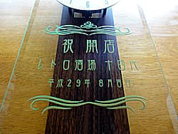 「祝開店、店名、オープンの日付」を前面ガラスに彫刻した、居酒屋の開店祝い用の電波式掛け時計
