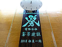 �u20th anniversary�A��Ђ̃}�[�N�A�Ј��ꓯ�v��O�ʃK���X�ɒ��������A�n��20���N�j���p�̊|�����v