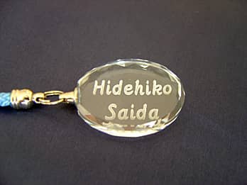 �ȉ~�`�̃K���X���̏��蕔�ɖ��O�𒤍������X�g���b�v