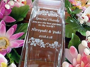 ���e�ւ̊��ӂ����߂����b�Z�[�W�A�V�Y�ƐV�w�̖��O�𑤖ʂɒ��������A���e�ւ̑��蕨�p�̃K���X�ԕr