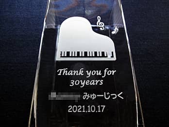 ピアノと音符のイラストを側面に彫刻した、音楽教室の周年祝い用のフラワーベース