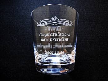 �u��Ж��ACongratulations new president�A�V�В��̖��O�A�A�C���̓��t�v�𑤖ʂɒ��������A�В��A�C�j���p�̃O���X