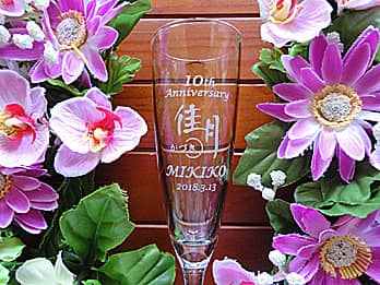 ���X�̃��S�}�[�N�𑤖ʂɒ��������A���H�X�̎��N�L�O�i�p�̃V�����p���O���X