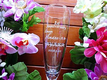 �u1st Anniversary�A�X���A���N���̓��t�v�𑤖ʂɒ��������A���H�X�̎��N�L�O�i�p�̃V�����p���O���X
