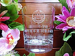 「校章、○○小学校、先生の名前、○年度卒業生一同」を側面に彫刻した、同窓会で恩師への記念品用のロックグラス
