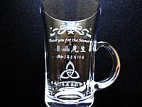 「校章」と「Thank you for the memories、○○先生、平成23年度○○小学校卒業生一同」を側面に彫刻した、同窓会で恩師へ贈るガラス製のティーカップ