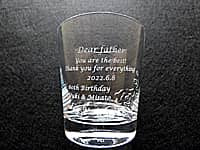 「Dear father You are the best! Thank you for everything! 60th Birthday、誕生日の日付、贈り主の名前」を側面に彫刻した、父親の還暦祝い用のロックグラス