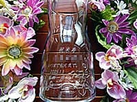 「祝米寿 いつまでもお元気で、贈る相手の名前、贈り主の名前」を側面に彫刻した、米寿祝い用のフラワーベース