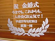 「祝 金婚式、家族一同より、日付」を彫刻した、両親への金婚式の贈り物用の鏡