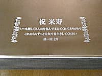 「祝米寿 いつも優しくみんなを包んで支えてくれてありがとう これからもずっと元気で長生きしてください 孫一同より」を彫刻した、祖父の米寿祝い用の鏡