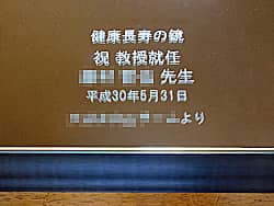 「祝 教授就任 ○○先生、○○一同より、日付」を彫刻した、教授就任祝い用の鏡