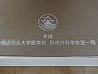 開院祝い用の名入れ鏡(形成外科学教室のマークと、寄贈○○大学医学部形成外科学教室一同を彫刻)