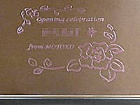 「Opening Celebration 店名 from 贈り主の名前」を鏡の表面に彫刻した、飲食店の開店祝い用の鏡