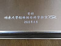 「寄贈 ○○大学脳神経内科学教室」と「大学のマーク」を鏡の表面に彫刻した、病院の開院祝い用の鏡