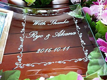 �uWith Thanks�A�V�Y�ƐV�w�̖��O�A�������̓��t�v�𒤍������A���e�փv���[���g����K���X���ʐ^����