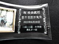「祝校長就任 ○○先生 ○○小学校教え子一同」を彫刻した、校長就任祝い用のガラス製写真立て