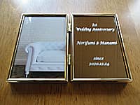 1st wedding anniversary、旦那様と奥様の名前、結婚記念日の日付を彫刻した、結婚1周年祝い用のブック型写真立て