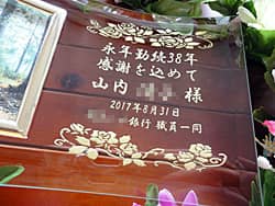 「永年勤続38年 感謝を込めて ○○様、○○銀行職員一同」を彫刻した、永年勤続の表彰記念品用のガラス製写真立て