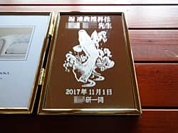 「祝准教授昇任 ○○先生、鯉の滝登りのイラスト」を彫刻した、准教授就任祝いの贈り物用のフォトスタンド