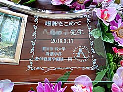 「校章、感謝を込めて ○○先生、○○大学○○学部一同」を彫刻した、卒業生から先生への贈り物用の写真立て