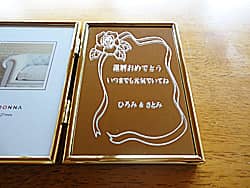 「還暦おめでとう、○○ & ○○より」を彫刻した、父親への還暦祝い用のピクチャーフレーム