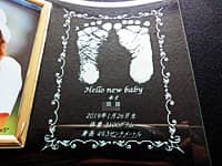 「赤ちゃんの足形」と「赤ちゃんの名前、生年月日、身長と体重」を彫刻した、両親への出産内祝い用のガラス製写真立て