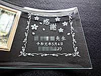 「感謝、○○先生、日付」を彫刻した、同窓会で恩師へ贈るプレゼント用のガラス製フォトスタンド