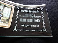 「教授御就任記念 ○○大学 ○○教授」を彫刻した、教授就任祝い用の写真立て