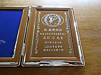 「祝教授就任 ○○大学 ○○先生」を彫刻した、就任祝い用のフォトフレーム