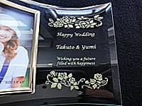 「Happy wedding、新郎と新婦の名前、Wishing you a furure filled with happiness」を彫刻した、結婚祝い用のガラス製フォトフレーム