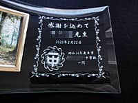 同窓会で恩師へ贈る写真立て(中学校の校章、感謝を込めて ○○先生 昭和54年度卒業○○中学校一同をガラス製の写真立てに彫刻)